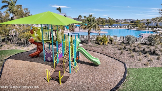 community play area featuring a community pool and fence