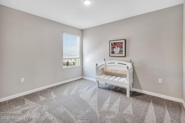 carpeted bedroom featuring baseboards