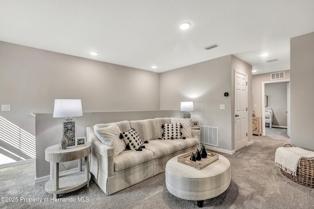 carpeted living area featuring baseboards, visible vents, and recessed lighting