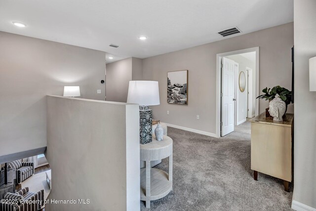 hallway with baseboards, visible vents, carpet, and recessed lighting