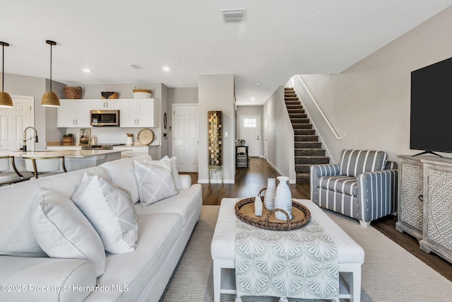living room with stairway, visible vents, recessed lighting, and dark wood-style floors