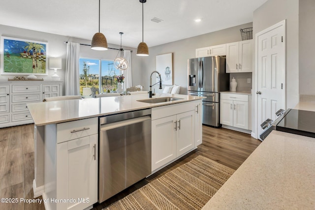 kitchen with dark wood-style flooring, a sink, stainless steel appliances, white cabinetry, and light countertops