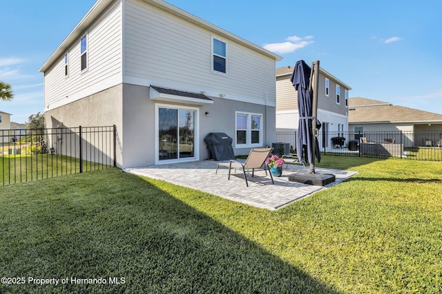 back of property with a patio, a fenced backyard, stucco siding, and a lawn