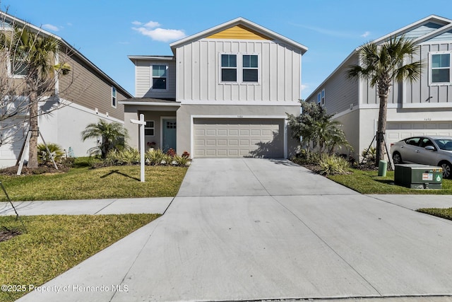 view of front of property featuring a garage, board and batten siding, a front yard, and concrete driveway