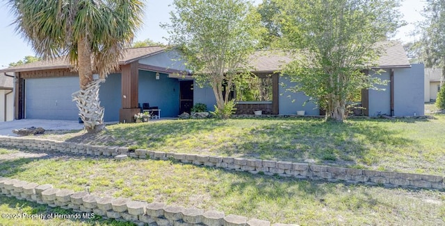 ranch-style home featuring a garage, stucco siding, concrete driveway, and a front lawn