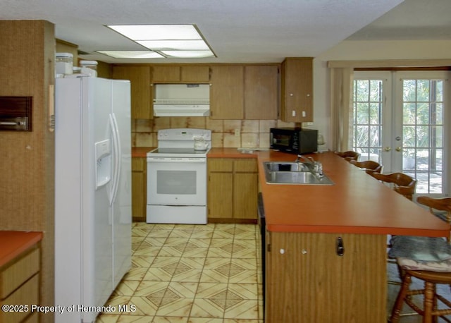 kitchen with french doors, range hood, a sink, a peninsula, and white appliances