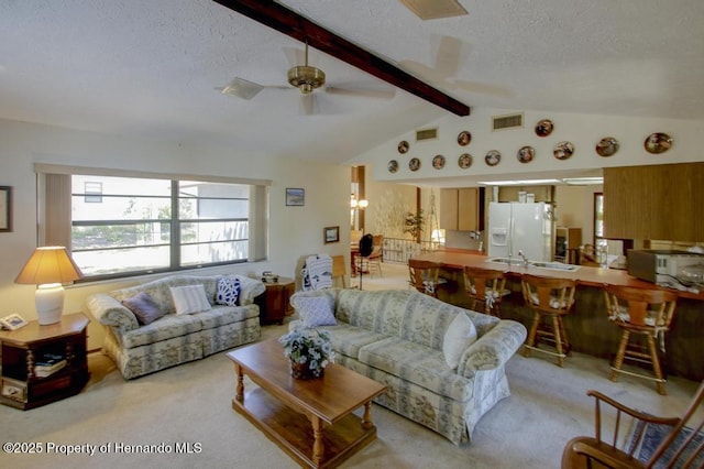 living room featuring visible vents, a textured ceiling, a wealth of natural light, and light carpet