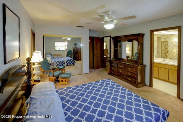 bedroom featuring visible vents, carpet floors, ceiling fan, wallpapered walls, and a sink