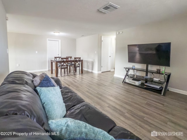 living room with baseboards, wood finished floors, and visible vents
