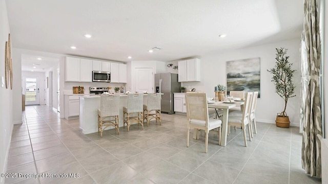 dining space with recessed lighting, baseboards, and light tile patterned floors