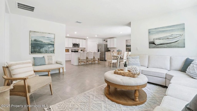 living room with recessed lighting, visible vents, and light tile patterned floors