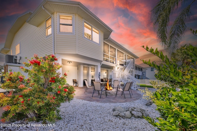 4285 Flexer Dr, Hernando Beach, FL 34607 - back of house featuring central air condition unit, stairway, a patio area, and an outdoor fire pit