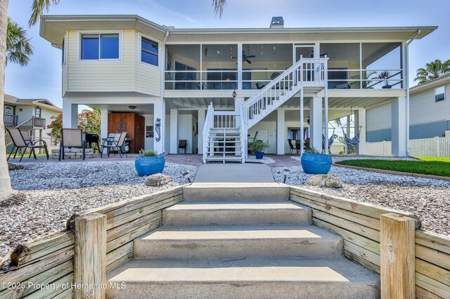 4285 Flexer Dr, Hernando Beach, FL 34607 - rear view of property with a sunroom and stairs