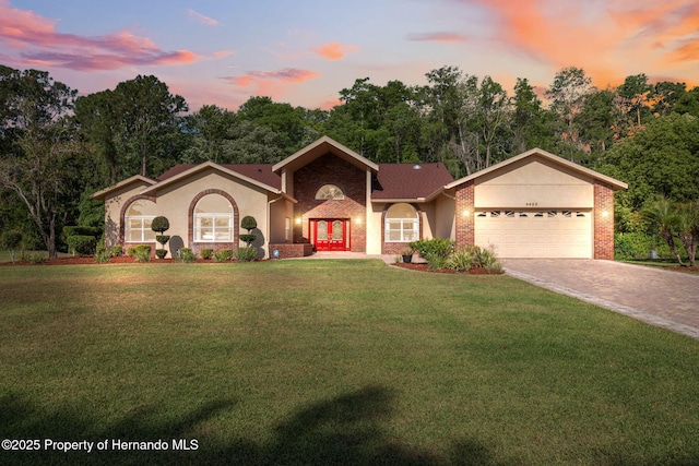 4469 Lake In The Woods Dr, Weeki Wachee, FL 34607 - view of front of property featuring stucco siding, driveway, french doors, a front yard, and an attached garage