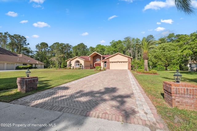 4469 Lake In The Woods Dr, Weeki Wachee, FL 34607 - view of front of property featuring a front lawn, decorative driveway, and a garage