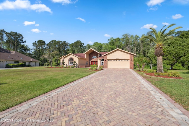 4469 Lake In The Woods Dr, Weeki Wachee, FL 34607 - ranch-style home featuring a front yard, a garage, decorative driveway, brick siding, and stucco siding