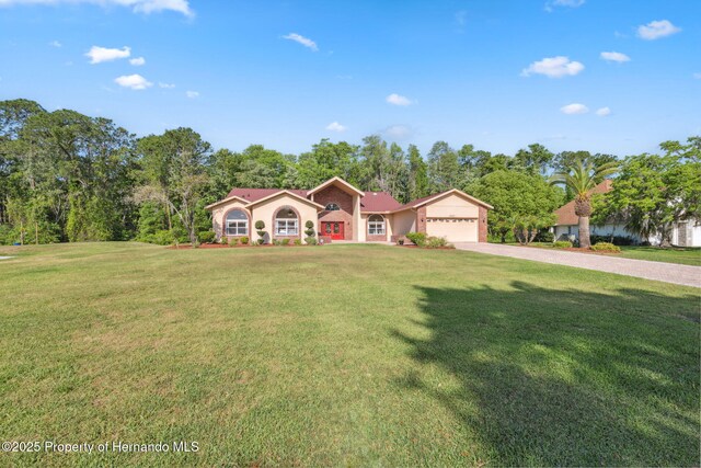 4469 Lake In The Woods Dr, Weeki Wachee, FL 34607 - view of front of home with a front lawn, driveway, an attached garage, and stucco siding