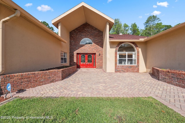 4469 Lake In The Woods Dr, Weeki Wachee, FL 34607 - entrance to property with stucco siding, a patio area, french doors, and brick siding