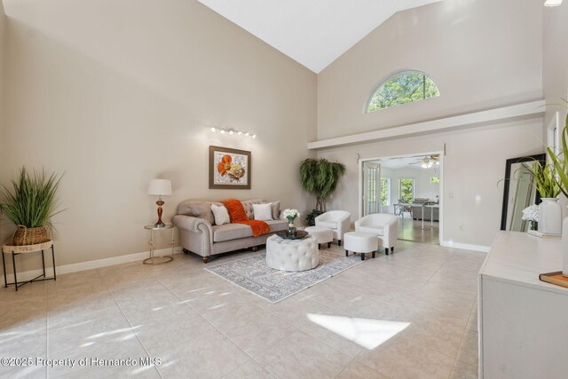 4469 Lake In The Woods Dr, Weeki Wachee, FL 34607 - living room with baseboards, high vaulted ceiling, a ceiling fan, and light tile patterned flooring
