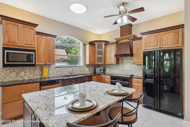 4469 Lake In The Woods Dr, Weeki Wachee, FL 34607 - kitchen featuring light stone countertops, a sink, a kitchen breakfast bar, black appliances, and a ceiling fan