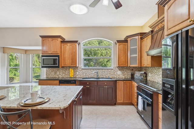 4469 Lake In The Woods Dr, Weeki Wachee, FL 34607 - kitchen featuring black appliances, a wealth of natural light, dark stone countertops, and a sink