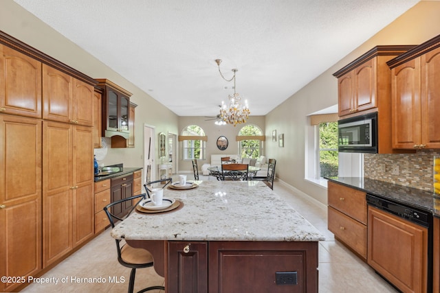 4469 Lake In The Woods Dr, Weeki Wachee, FL 34607 - kitchen with stainless steel microwave, light tile patterned floors, a notable chandelier, tasteful backsplash, and a center island
