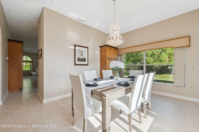 4469 Lake In The Woods Dr, Weeki Wachee, FL 34607 - dining space featuring light tile patterned floors, a notable chandelier, and baseboards