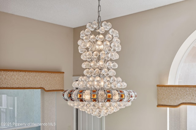 4469 Lake In The Woods Dr, Weeki Wachee, FL 34607 - details featuring a textured ceiling and an inviting chandelier