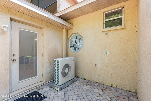 4469 Lake In The Woods Dr, Weeki Wachee, FL 34607 - exterior space with brick floor, laundry area, ac unit, and a textured wall