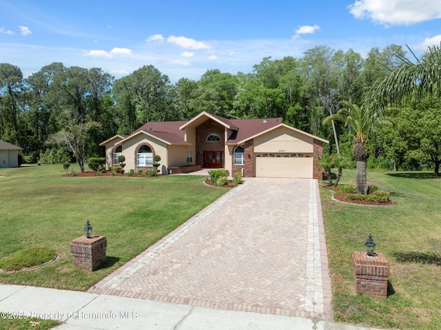 4469 Lake In The Woods Dr, Weeki Wachee, FL 34607 - view of front of house featuring a front lawn, decorative driveway, and an attached garage