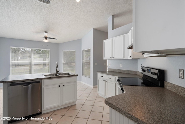 kitchen featuring appliances with stainless steel finishes, a sink, a ceiling fan, white cabinetry, and dark countertops