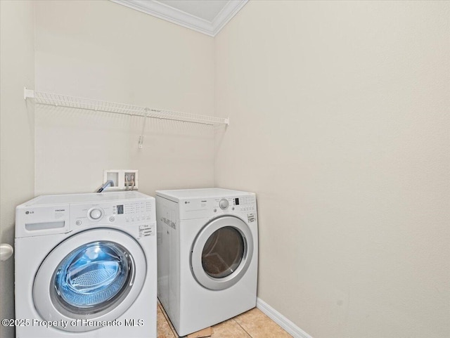 washroom featuring crown molding, separate washer and dryer, baseboards, and light tile patterned floors