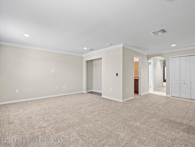 unfurnished living room with arched walkways, light carpet, recessed lighting, crown molding, and baseboards