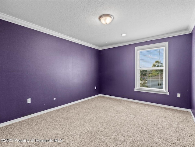 empty room featuring carpet floors, ornamental molding, baseboards, and a textured ceiling