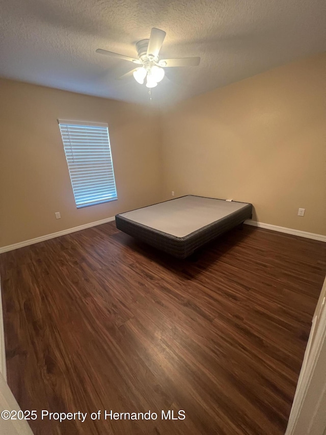 15297 Myland Rd, Weeki Wachee, FL 34614 - bedroom with dark wood-style floors, baseboards, ceiling fan, and a textured ceiling