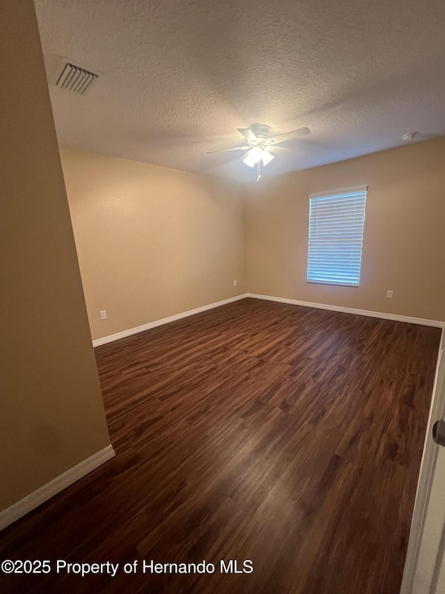 15297 Myland Rd, Weeki Wachee, FL 34614 - unfurnished room with dark wood-style floors, visible vents, ceiling fan, and a textured ceiling
