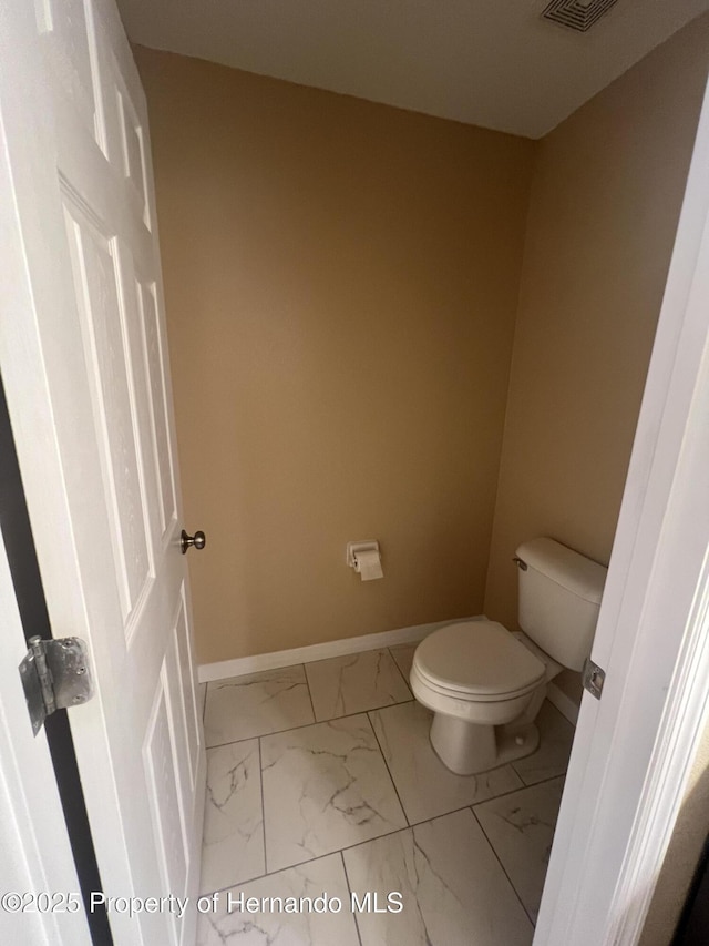 15297 Myland Rd, Weeki Wachee, FL 34614 - bathroom featuring toilet, marble finish floor, visible vents, and baseboards