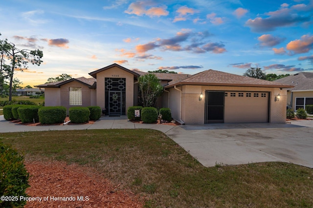 9208 Butler Blvd, Weeki Wachee, FL 34613 - ranch-style house with a lawn, driveway, an attached garage, and brick siding