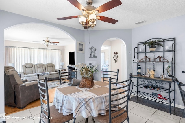 9208 Butler Blvd, Weeki Wachee, FL 34613 - dining area featuring visible vents, arched walkways, ceiling fan, and light tile patterned floors