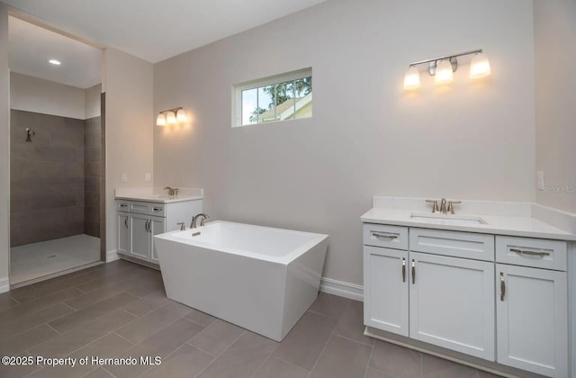 6063 Dusk Rose Ln, Brooksville, FL 34601 - bathroom with vanity, a tile shower, a soaking tub, and baseboards