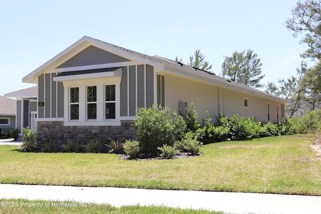 6063 Dusk Rose Ln, Brooksville, FL 34601 - view of property exterior with stone siding and a yard