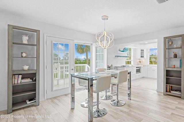 dining area with a notable chandelier and light wood-style flooring