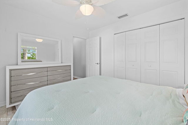 bedroom with baseboards, a ceiling fan, visible vents, and a closet