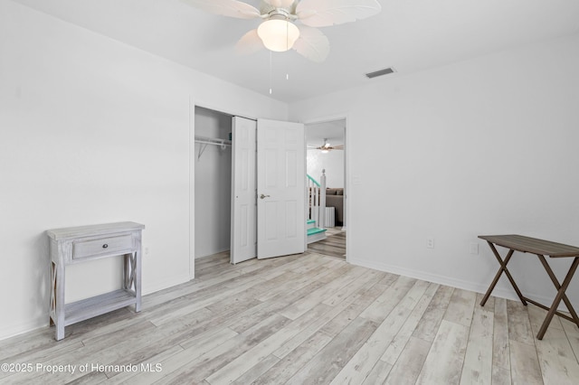 unfurnished bedroom with visible vents, wood finished floors, and a closet
