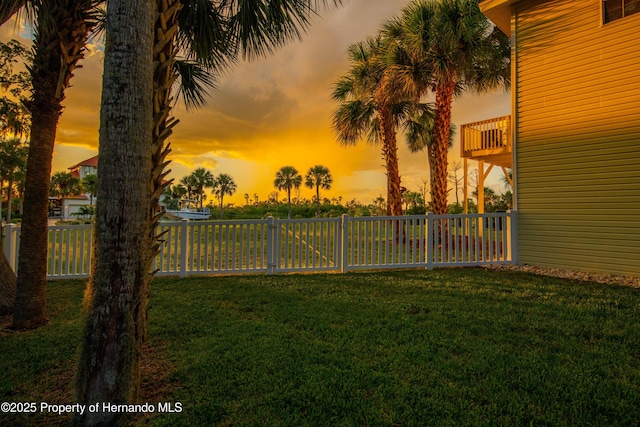 yard at dusk with fence and a balcony