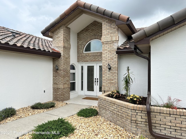 10519 Audie Brook Dr, Spring Hill, FL 34608 - entrance to property with french doors, stucco siding, and a tile roof