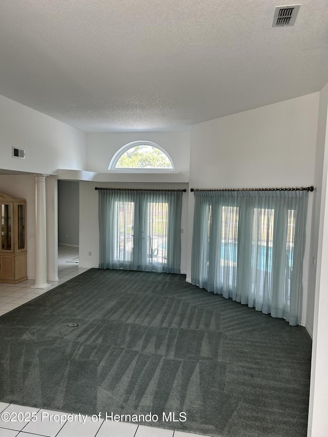 10519 Audie Brook Dr, Spring Hill, FL 34608 - carpeted empty room with decorative columns and a textured ceiling