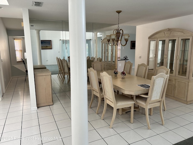 10519 Audie Brook Dr, Spring Hill, FL 34608 - dining room with ornate columns, a chandelier, and light tile patterned floors