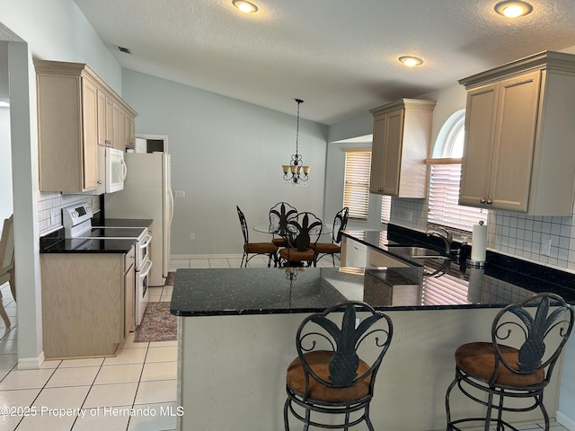 10519 Audie Brook Dr, Spring Hill, FL 34608 - kitchen featuring white appliances, vaulted ceiling, tasteful backsplash, a peninsula, and a textured ceiling