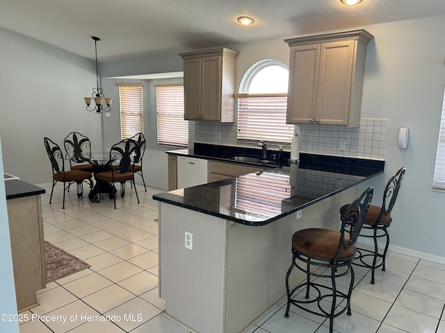 10519 Audie Brook Dr, Spring Hill, FL 34608 - kitchen with white dishwasher, a sink, decorative backsplash, and a kitchen bar